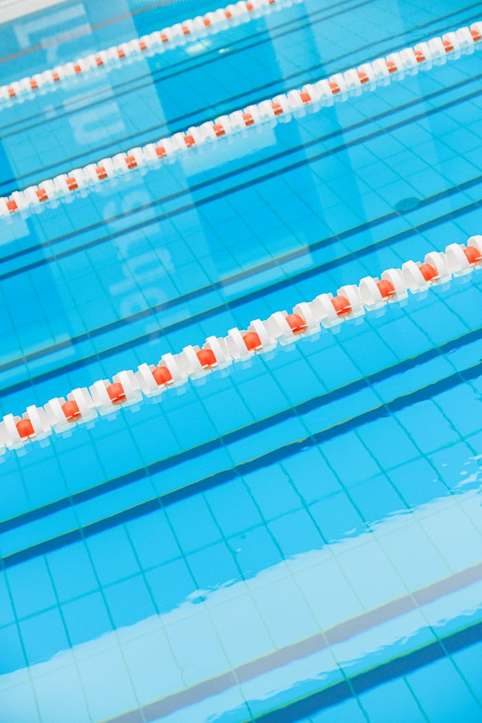 Indoor swimming pool with clear blue water and lane dividers. Perfect for sports and recreation imagery.